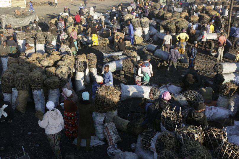 People gather to buy charcoal at a busy market in Lusaka, July 2021
