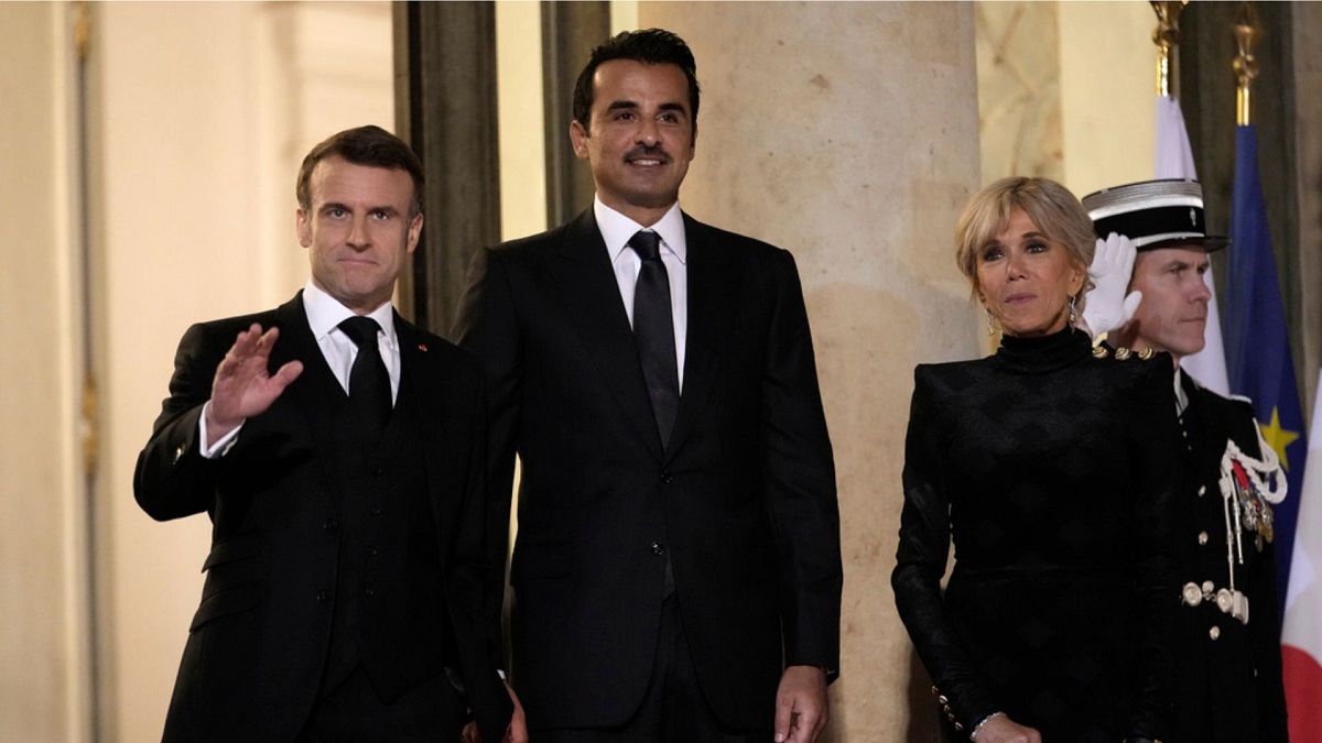 Qatar's Emir Sheikh Tamim bin Hamad Al Thani, center, French President Emmanuel Macron, left, and his wife Brigitte pose before a state dinner at the Elysee Palace in Paris, T