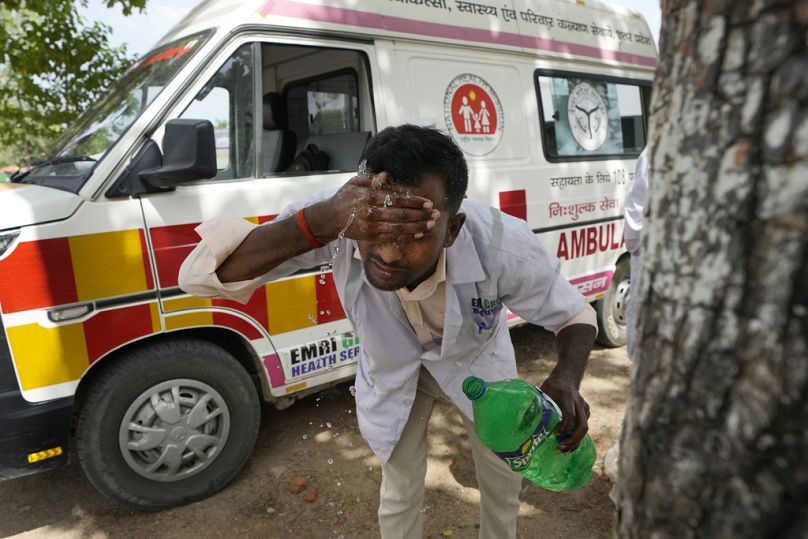 A paramedic washes his face with water to cool himself off after dropping a patient at Lalitpur district hospital, in Banpur, June 2023