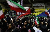 Iranian women wave their country's flags during an election campaign rally ahead of the March 1, parliamentary and Assembly of Experts elections, in Tehran on Feb. 27.