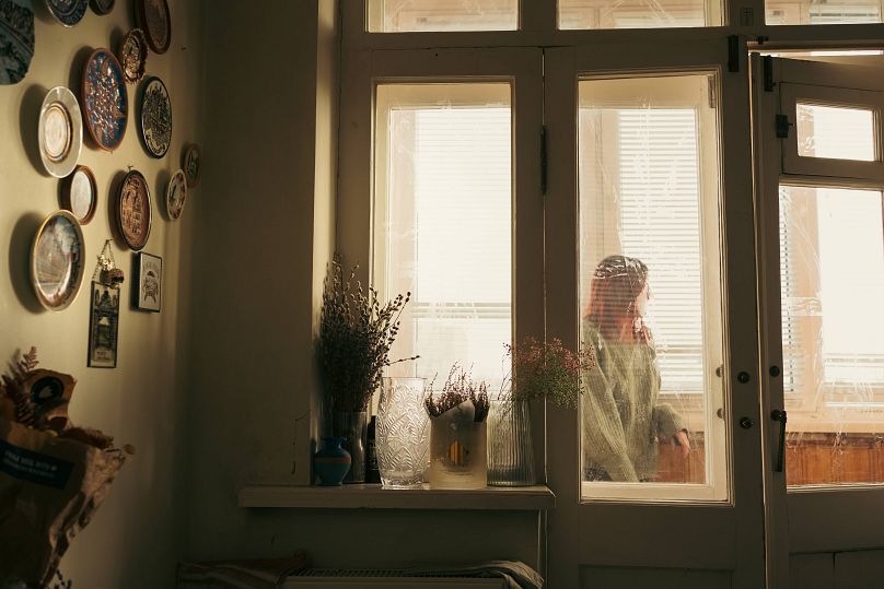 Anna looking out the window in her friend's home. She left her home during the Russian invasion on 24 February 2022.