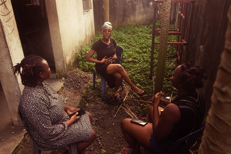 Ife with her family outside their home in Nigeria.