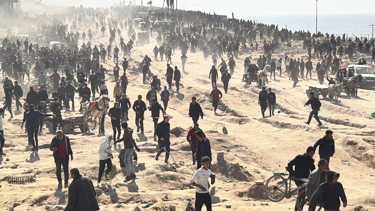 فلسطينيون ينتظرون المساعدات الإنسانية على شاطئ البحر في مدينة غزة، قطاع غزة، الأحد، 25 فبراير، 2024.