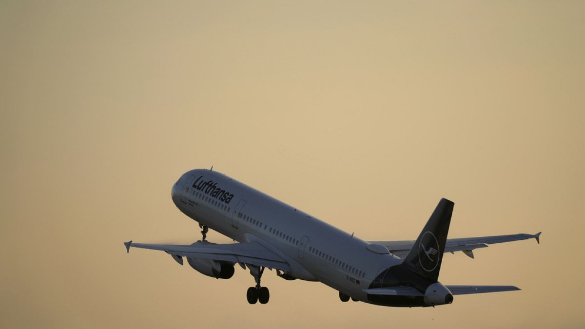 Самолет Airbus A321 авиакомпании Lufthansa взлетает из Лиссабона на восходе солнца