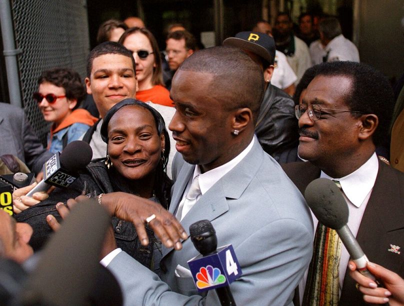 Sean Combs surrounded by fans and media as he and his attorney, Johnnie Cochran, right, leave State Supreme Court in New York, 16 May 2000.