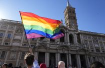 Un manifestante ondea la bandera del arco iris frente a la Basílica de Santa María la Mayor durante la marcha anual del Orgullo, en Roma, el sábado 26 de junio de 2021.