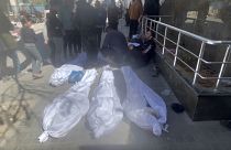 جثث على الأرض ملفوفة بأكفان بيضاء أمام مستشفى الشفاء في مدينة غزة