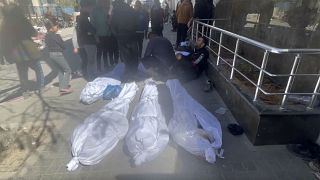 جثث على الأرض ملفوفة بأكفان بيضاء أمام مستشفى الشفاء في مدينة غزة