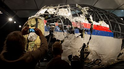 Journalists take images of part of the reconstructed forward section of the fuselage of the Malaysia Airlines plane shot down over Ukraine in 2014.