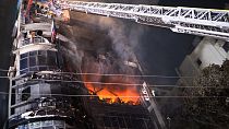 Pompieri cercano di spegnere un incendio divampato in un complesso commerciale a Dacca, in Bangladesh