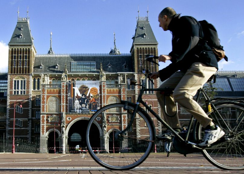 A cyclist passes the Rijksmuseum in Amsterdam, October 2004