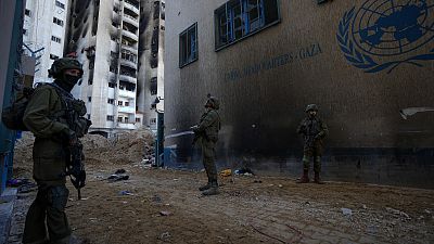 Израильские солдаты занимают позицию у штаб-квартиры БАПОР в Газе 8 февраля 2024 года.