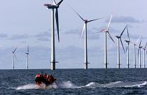 A speed rubber-boat passes by turbines in the North Sea, 14 kilometers west of the small village of Blavand near Esbjerg, Denmark.