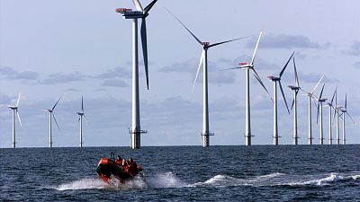 Un gommone passa accanto alle turbine nel Mare del Nord, 14 chilometri a ovest del piccolo villaggio di Blavand, vicino a Esbjerg, in Danimarca.