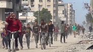 فلسطينيون يركضون لجمع المساعدات التي أسقطتها طائرة أردنية شمال قطاع غزة