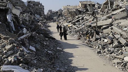 Palestinians walk through the destruction from the Israeli offensive in Jabaliya refugee camp in the Gaza Strip on Thursday, Feb. 29, 2024