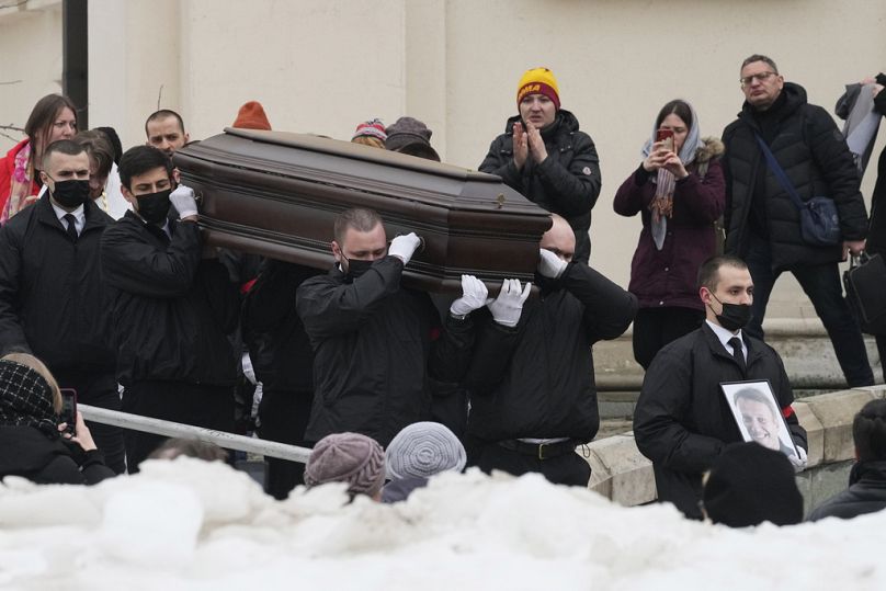 Workers carry the coffin and a portrait of Russian opposition leader Alexei Navalny out of the Church of the Icon of the Mother of God Soothe My Sorrows, in Moscow, Russia.