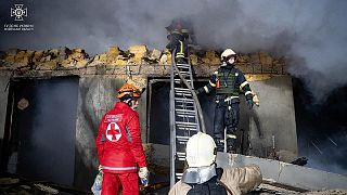 Des pompiers travaillent sur le site d'un bâtiment en feu après une attaque russe à Odessa, en Ukraine, le vendredi 23 février 2024.