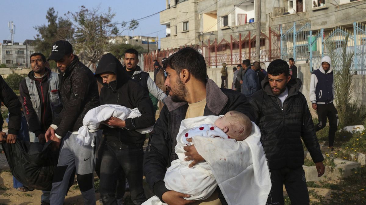 مشيعون يحملون جثتي توأمين فلسطينيين قُتلا في غارة إسرائيلية على منزل في رفح، جنوب قطاع غزة، 3 مارس، 2024.