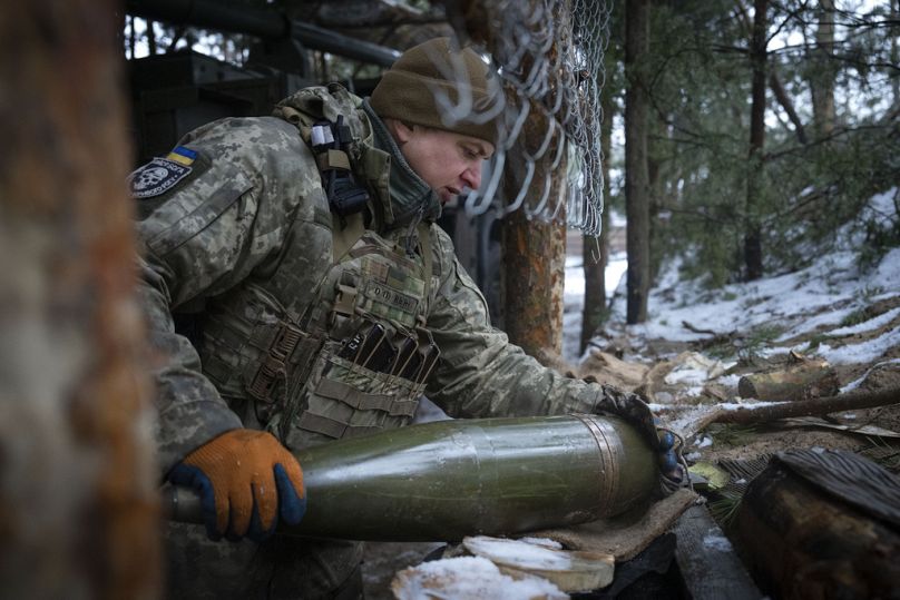 Ukrán katona lőszert készít elő egy taracknak a frontvonalban