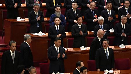 Председатель Китая Си Цзиньпин (в центре) аплодирует рядом с премьер-министром Китая Ли Цяном (справа) во время открытия сессии Народного политического консультативного совета