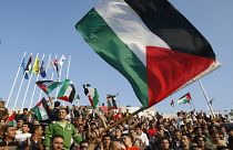 مشجعو كرة القدم الفلسطينية يلوحون بالأعلام الفلسطينية قبل مباراة كرة قدم
