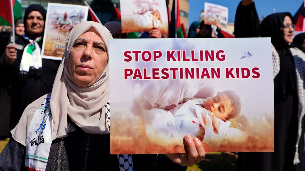 متظاهرة تحمل لافتة مكتوب عليها أوقفوا قتل الأطفال الفلسطينيين في بيروت، لبنان