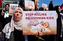 متظاهرة تحمل لافتة مكتوب عليها أوقفوا قتل الأطفال الفلسطينيين في بيروت، لبنان