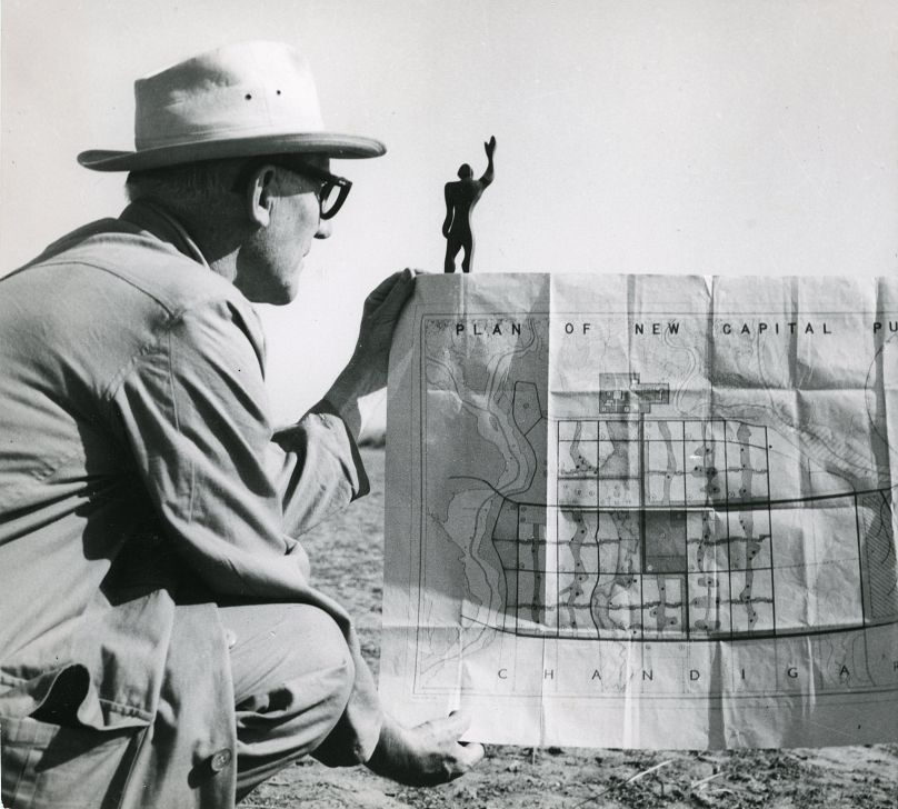 Le Corbusier in Chandigarh with the plan of the city and a model of the Modular Man, his universal system of proportion, 1951