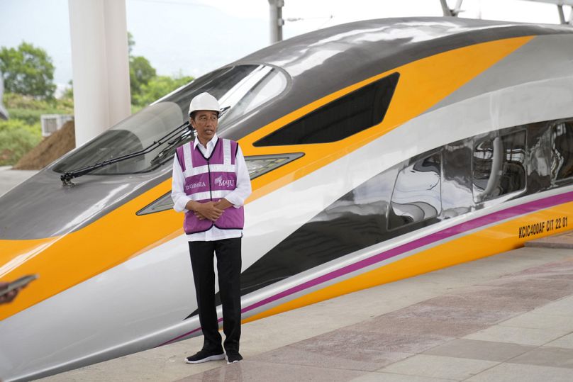 Indonesian President Joko Widodo stands near a newly-unveiled CIT unit during his visit at the Jakarta-Bandung Fast Railway station in Tegalluar, October 2022