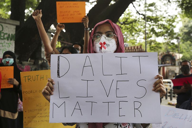 Manifestantes sostienen carteles durante una protesta que condena la presunta violación en grupo y el asesinato de una mujer dalit, en Bengaluru, India.