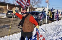 Donald Trump supporter Charles Tuttle, of Minot, sets out a row of Trump flags outside Minot Municipal Auditorium, where voting in the GOP caucus took place 4 March 2024