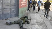 Varios peatones pasan junto a un soldado que vigila la zona del aeropuerto internacional de Puerto Príncipe, Haití, el lunes 4 de marzo de 2024.