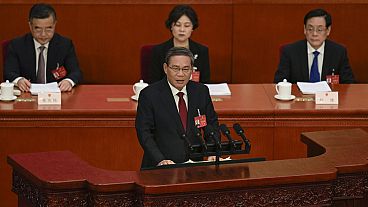 Chinese Premier Li Qiang, center, speaks during the opening session of the NPC at the Great Hall of the People in Beijing, China, Tuesday, March 5 2024