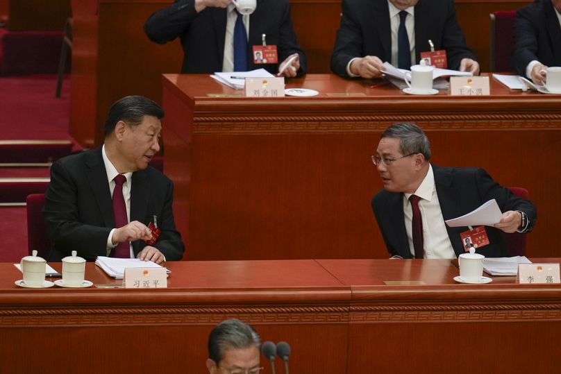 Chinese President Xi Jinping, left, talks with Chinese Premier Li Qiang during the opening session of the NPC at the Great Hall of the People in Beijing, China, 05/03/24