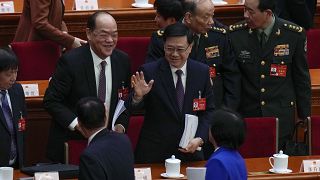 الرئيس التنفيذي لهونج كونج جون لي يلوح للمندوبين بعد الجلسة الافتتاحية للمجلس الوطني لنواب الشعب الصيني