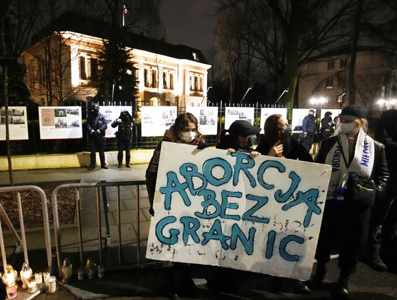 Aktivisták egy csoportja "Abortusz határok nélkül" feliratú táblával tüntet Lengyelország szigorú abortuszellenes törvénye ellen a varsói legfelsőbb alkotmánybíróság előtt.