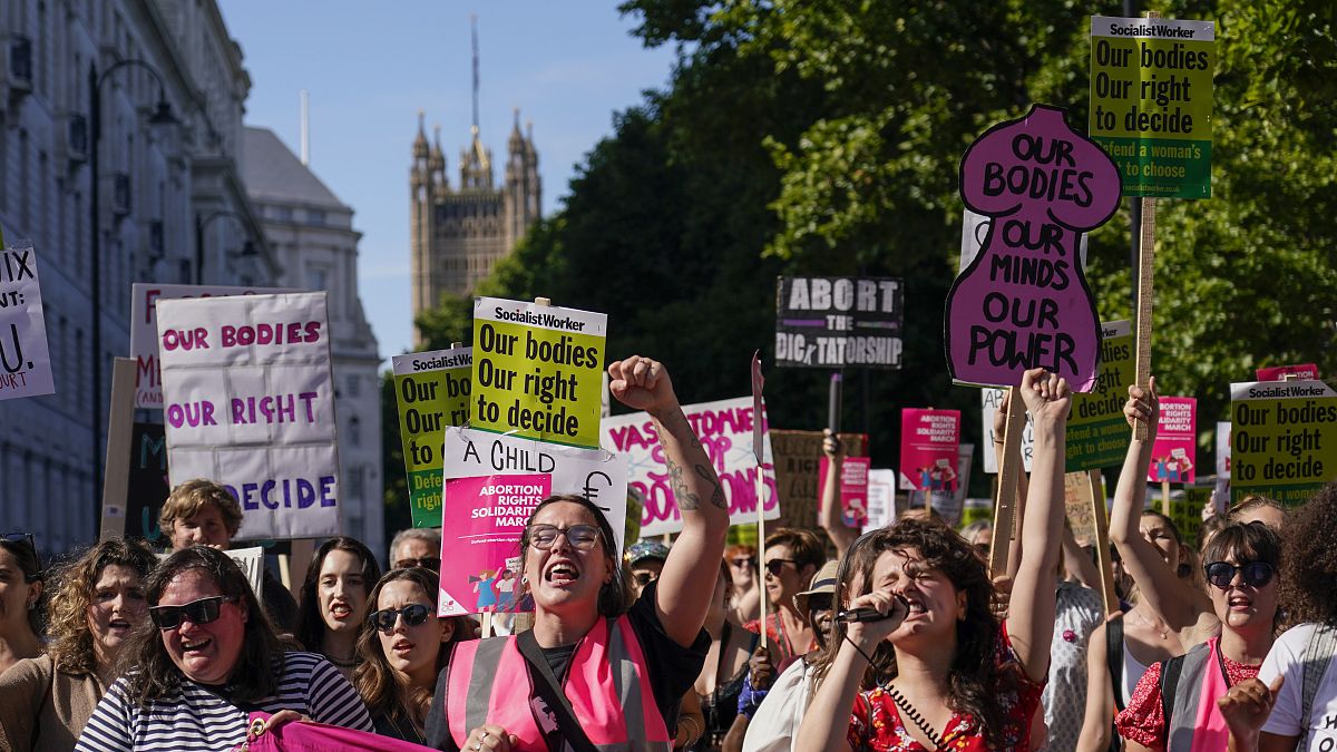  Demonstrators hold placards as they attend a march in support of the Abortion Rights group, in London, on July 9, 2022.