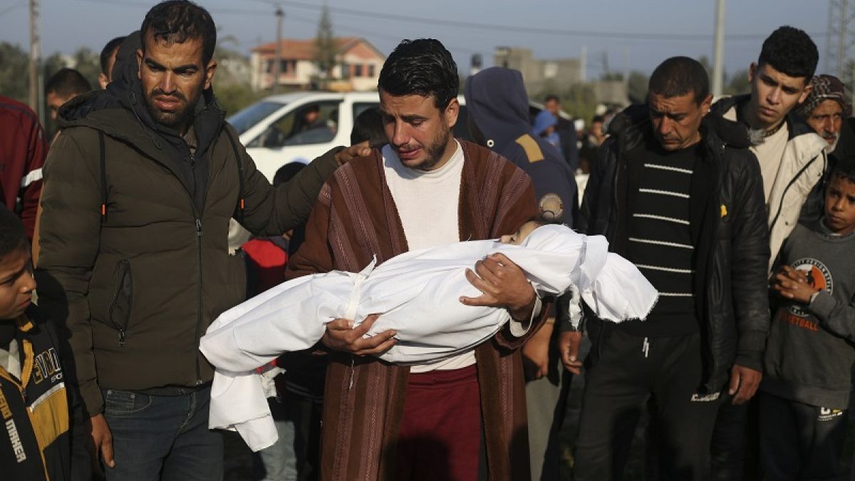 Abdul Rahman Sharif porta il corpo del figlio di quattro anni, ucciso dai bombardamenti israeliani sulla Striscia di Gaza, al suo funerale a Khan Younis (26 febbraio 2024)