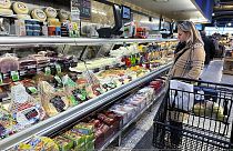 A woman checks prices as she shops at a grocery store in Wheeling, Ill., Friday, Jan. 19, 2024. 