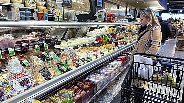 Una donna controlla i prezzi mentre fa la spesa in un negozio di alimentari a Wheeling, in Ill, venerdì 19 gennaio 2024. 