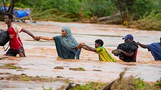 Moradores atravessam uma estrada danificada pelas chuvas do El Niño em Tula, no condado de Tana River, no Quénia, em 25 de novembro de 2023. 