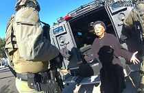 این عکس از فیلم دوربین پلیس دنور گرفته شده که روبی جانسون ۷۸ ساله را نشان می‌دهد که توسط افسران سوات محاصره شده است