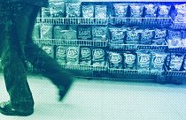 A convenience store customer walks past a shelf of salty snacks in Boston, July 2005