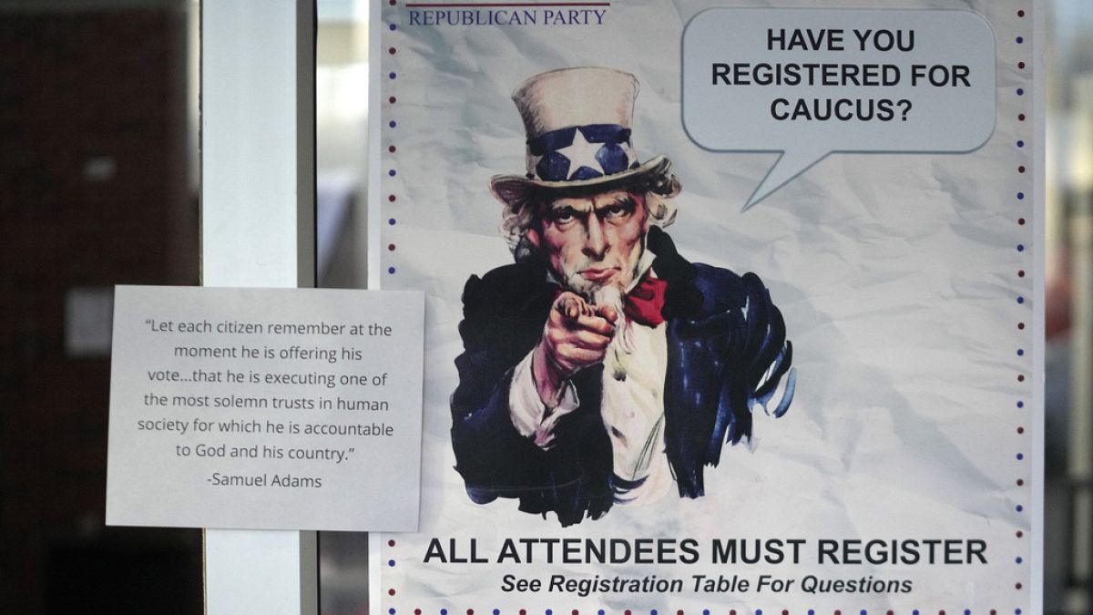 A HAVE YOU REGISTERED FOR CAUCUS sign hangs on a doorway during the Republican caucus at the Millcreek Junior High School on Tuesday, March 5, 2024, in Bountiful, Utah.