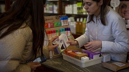 A woman receives an underwear for periods free of charge at a pharmacy in Barcelona, Spain, Tuesday, March 5, 2024.