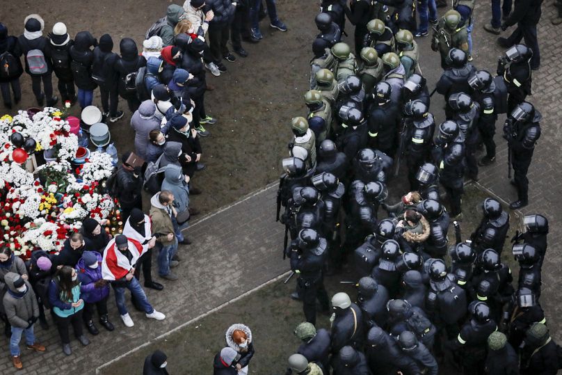 La polizia antisommossa bielorussa blocca i manifestanti durante una manifestazione dell'opposizione a Minsk, novembre 2020