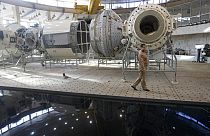 Moskova yakınlarındaki Rus Kozmonotlar Eğitim Merkezi'nde yer alan Uluslararası Uzay İstasyonu maketinin önünden geçen bir Rus mühendis (arşiv)
