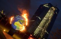 A makeshift globe burns in front of the ECB in Frankfurt, Germany, as activists protest against the bank's climate policy, Oct. 21, 2020. 