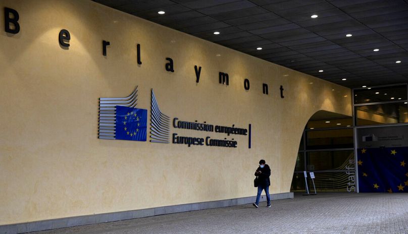 A man walks past the entrance of EU headquarters in Brussels, December 2020